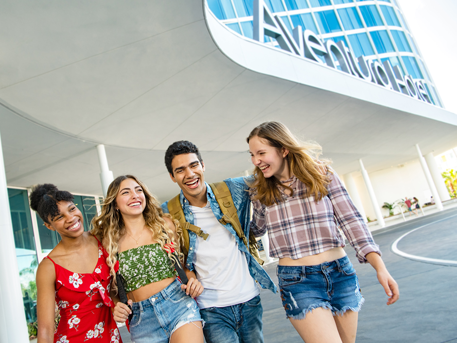Four friends walk outside of Aventura Hotel.
