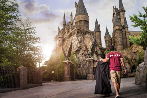 A boy and his father walk toward the Hogwarts Castle.