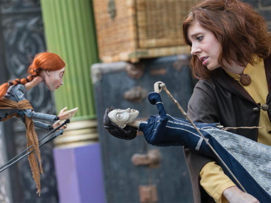 A performer interacts with puppets during the Tales of Beedle the Bard in Diagon Alley