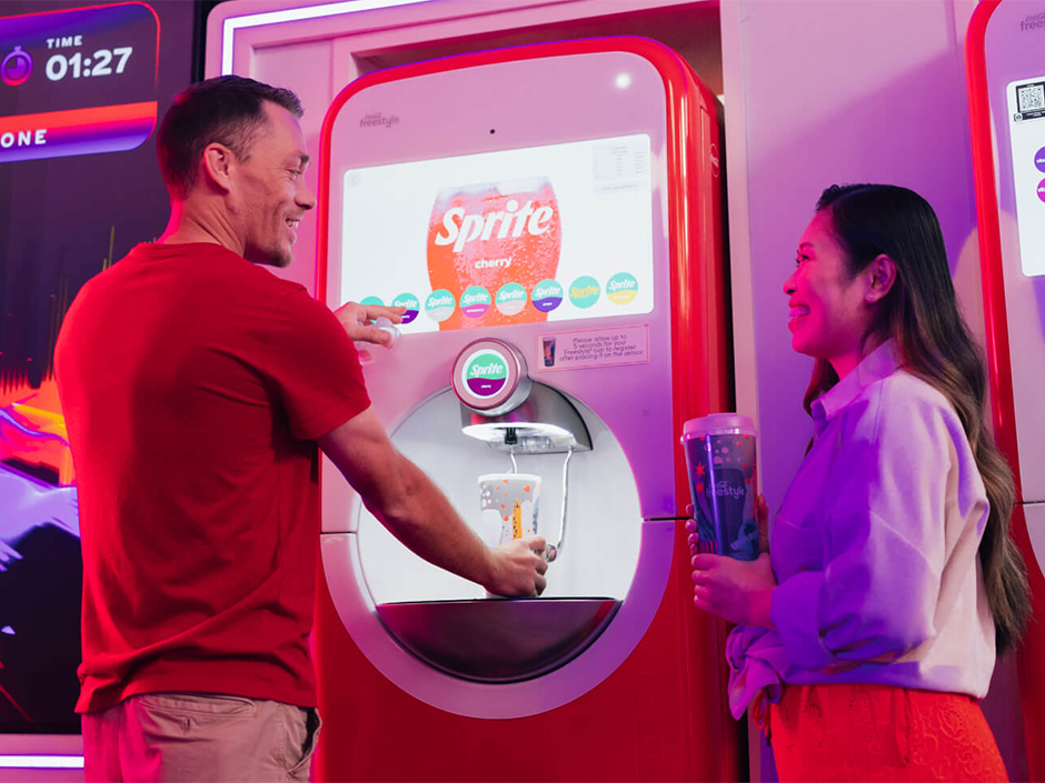A woman and a man use the Coke Freestyle Machine at Universal Orlando Resort.