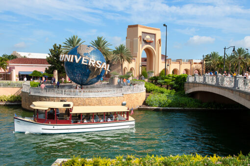 A water taxi passes by the entrance of Universal Studios Florida.