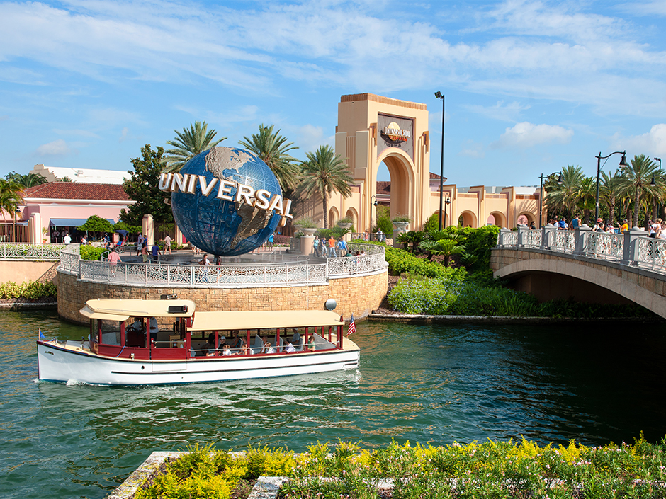 A water taxi passes by the entrance of Universal Studios Florida.