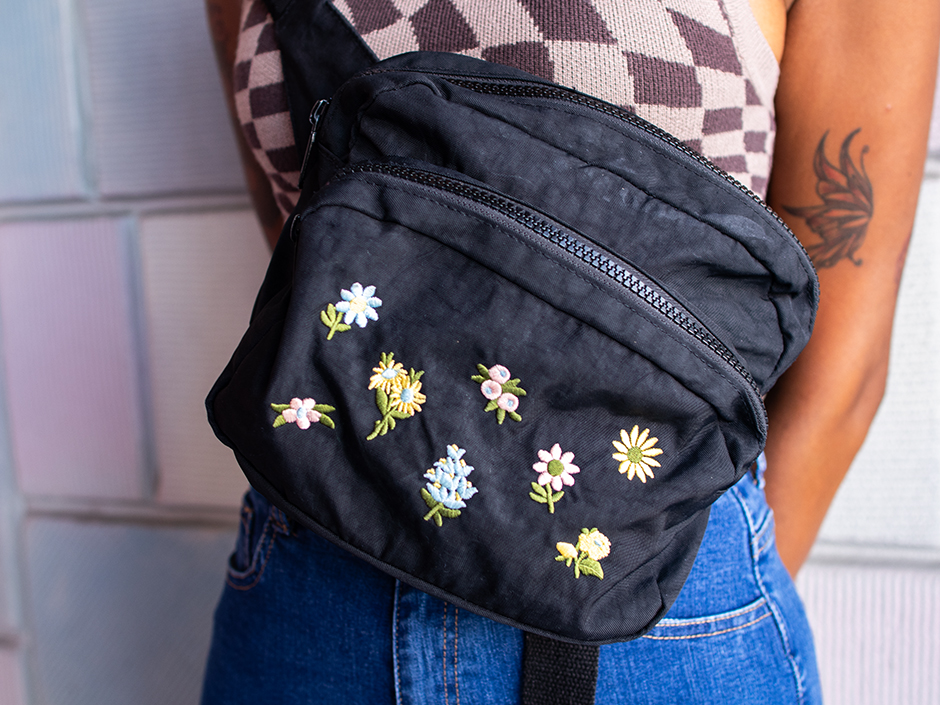 A person wearing a small, cross-body bag in a theme park