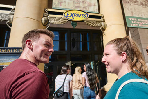 Two people smile at each other as they head into a Universal Express queue.