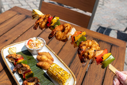 Hand holding a shrimp skewer for Jamaica's Independence Day at Bob Marley's in Universal CityWalk.