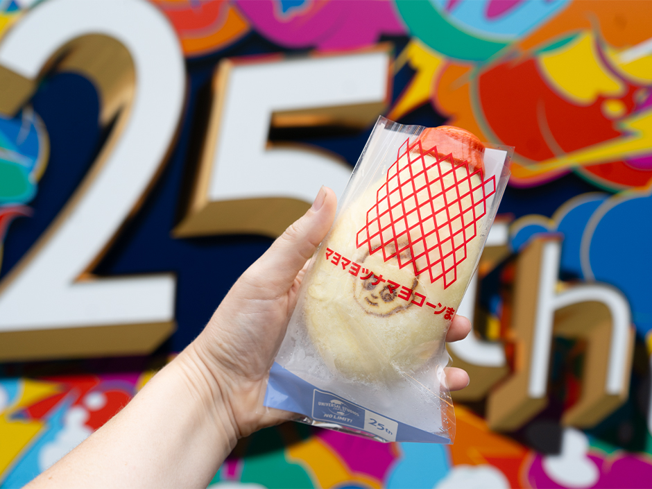 A kewpie bun with a sign for USJ's 25th anniversary in the background