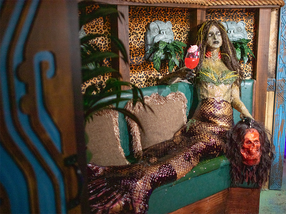 A scary mermaid lounges in the tiki bar of the H.R. Bloodengutz haunted house at HHN