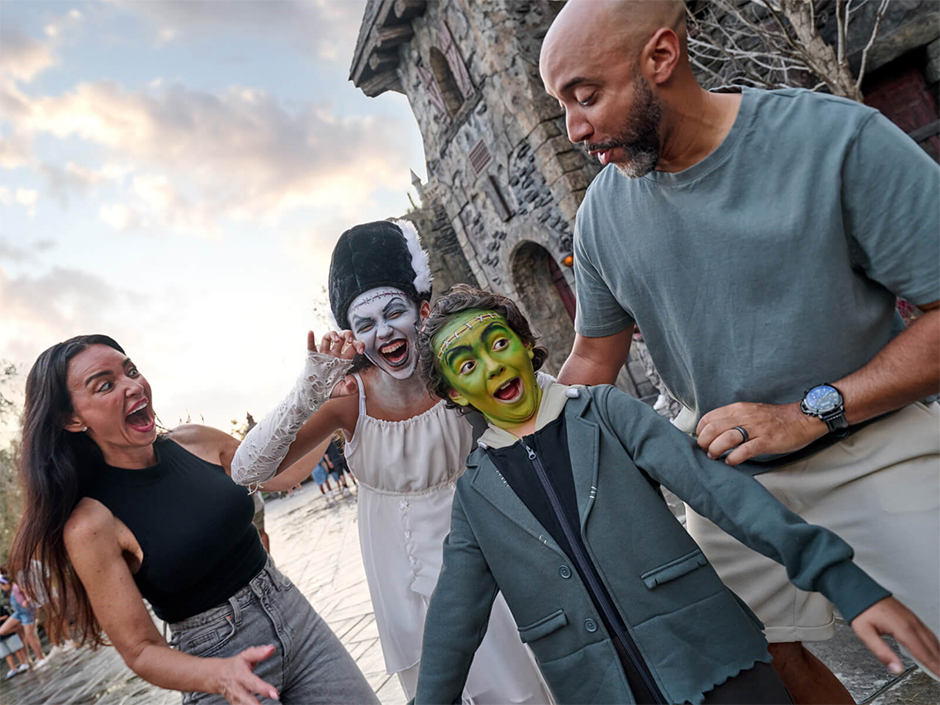 A family laugh together in Darkmoor. The boy and girl have their faces painted like Frankenstein and the Bride of Frankenstein