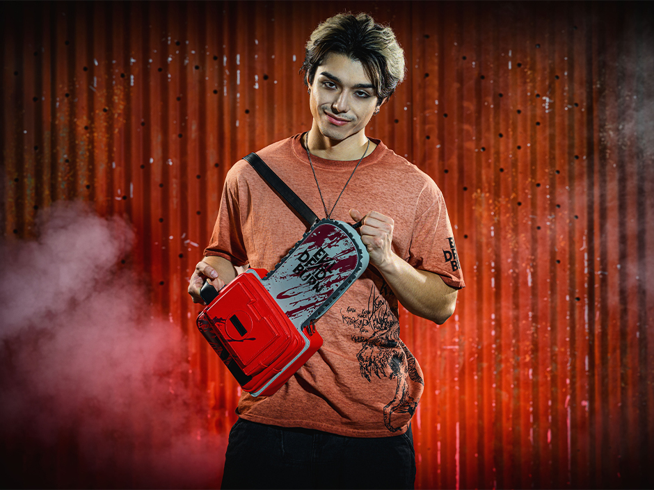 A guest poses with their Evil Dead chainsaw purse