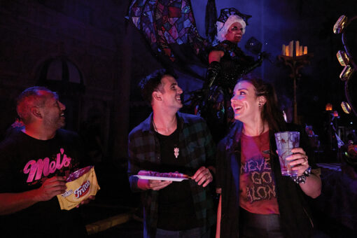 Three friends laugh together over snacks at Halloween Horror Nights in Universal Studios Florida