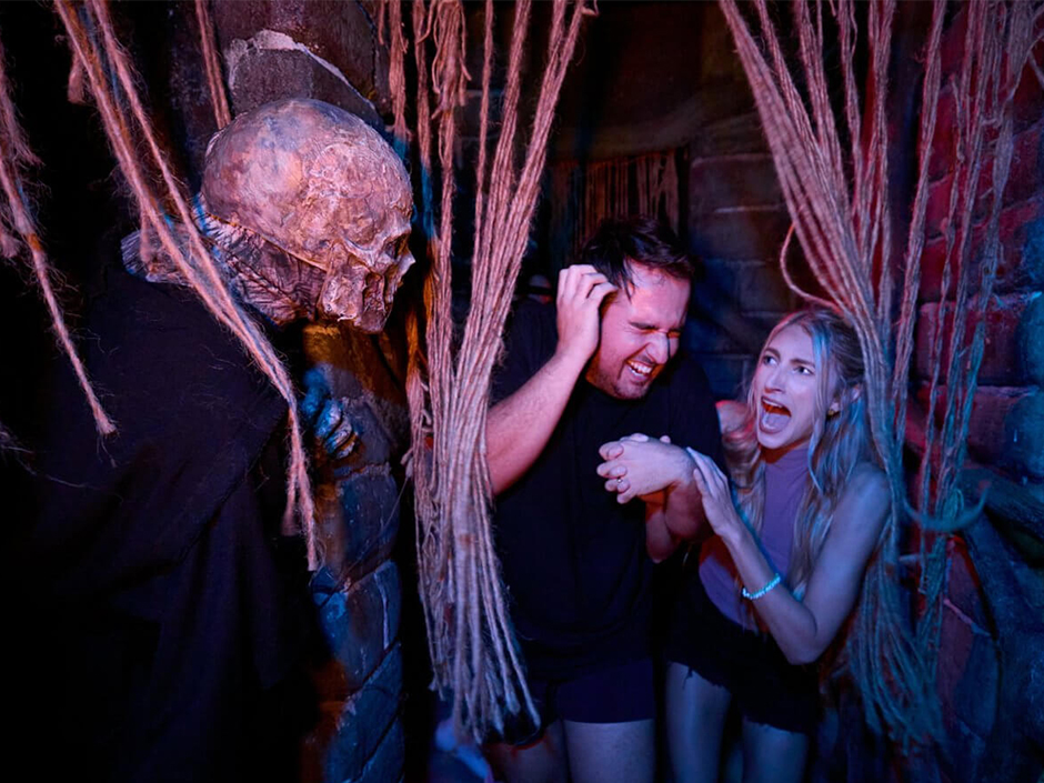 Two friends scream from a jump scare in a haunted House at HHN