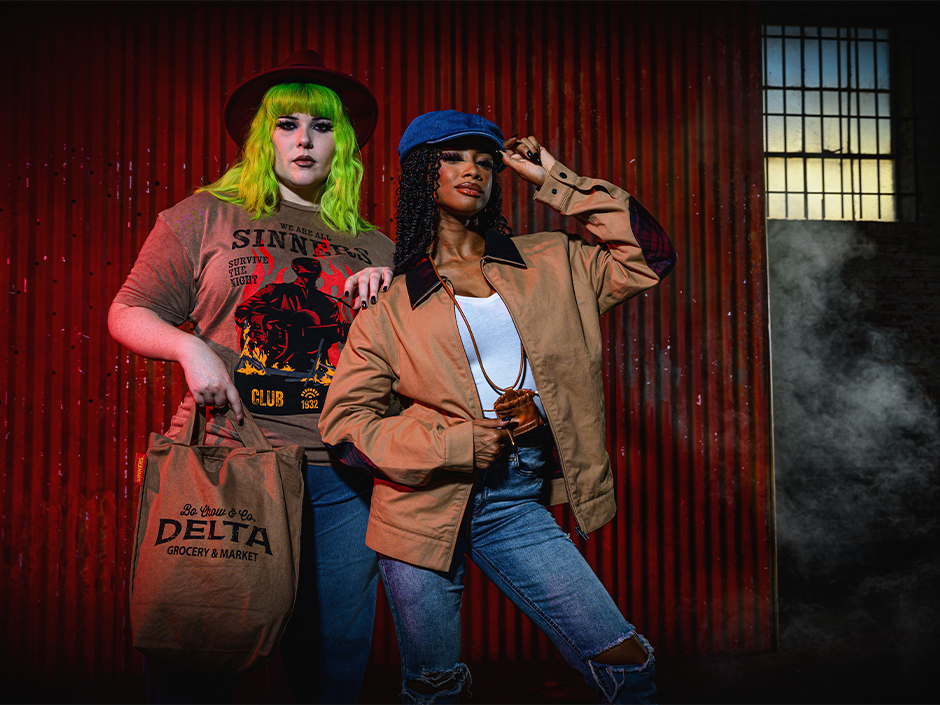 Two friends poses in some of the Sinners merch items available at Halloween Horror Nights this year