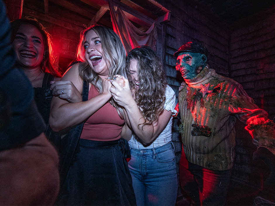 Three girls screaming in a haunted house at HHN at Universal Studios Florida
