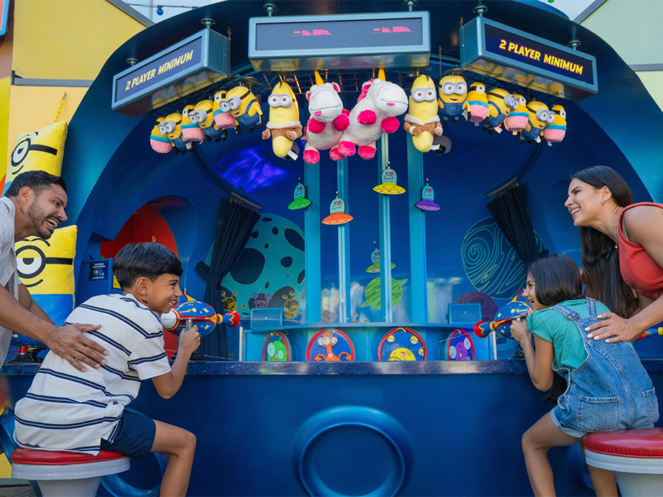 Two kids face off in a carnival game in Minion Land.