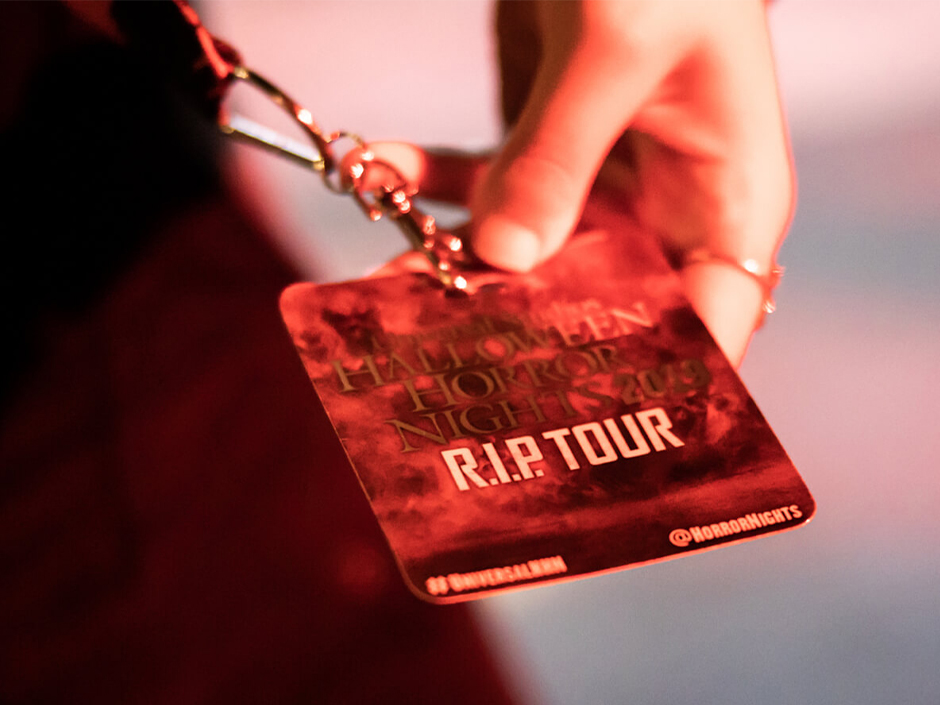 A guest holds out their RIP Tour badge at HHN