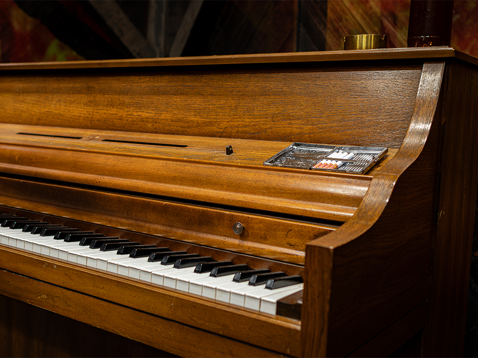 Image of a piano with prop cigarettes from the Sinners haunted house at HHN at Universal Orlando Resort.