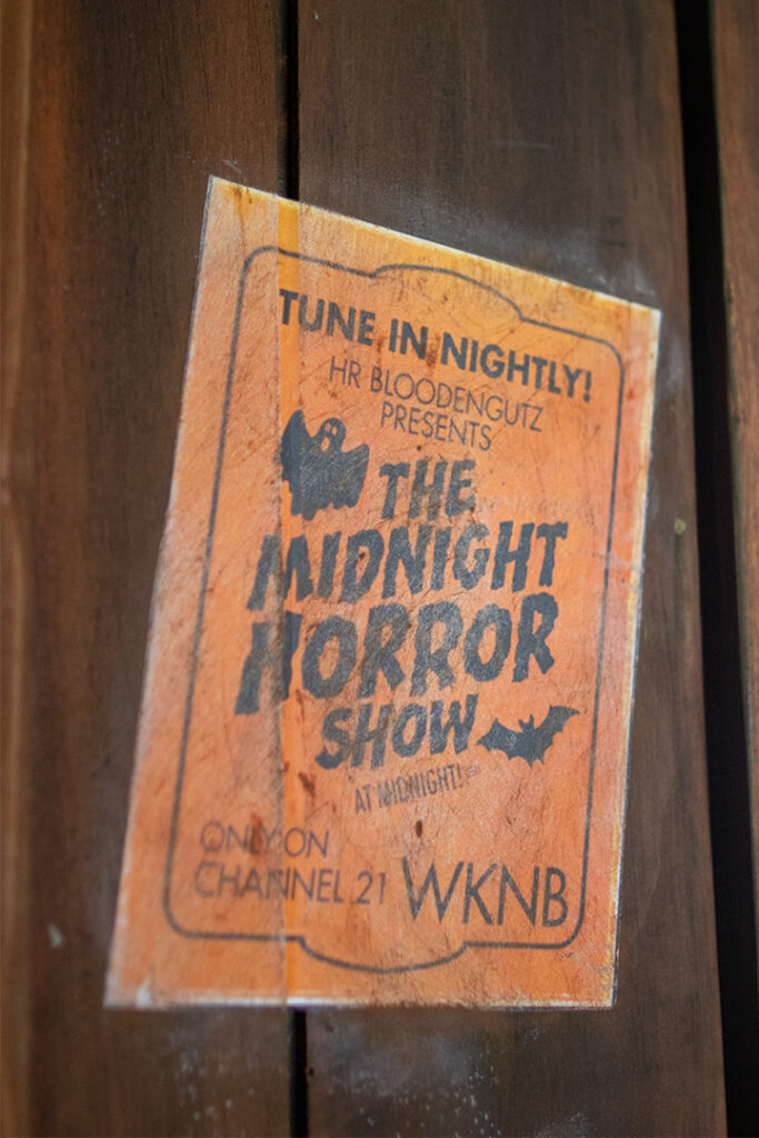 A grungy poster for The Midnight Horror Show inside of the H.R. Bloodengutz haunted house at HHN