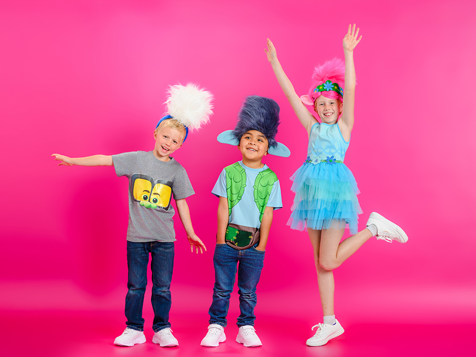 Three children are wearing various Universal Kids Resort themed merchandise