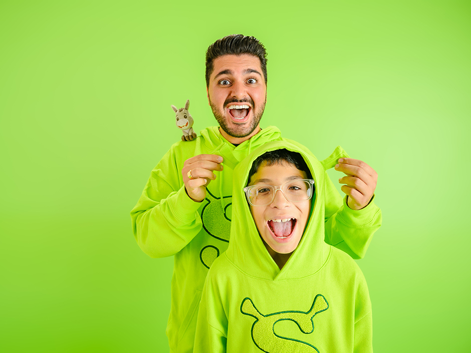 A man and a child are wearing Shrek merchandise