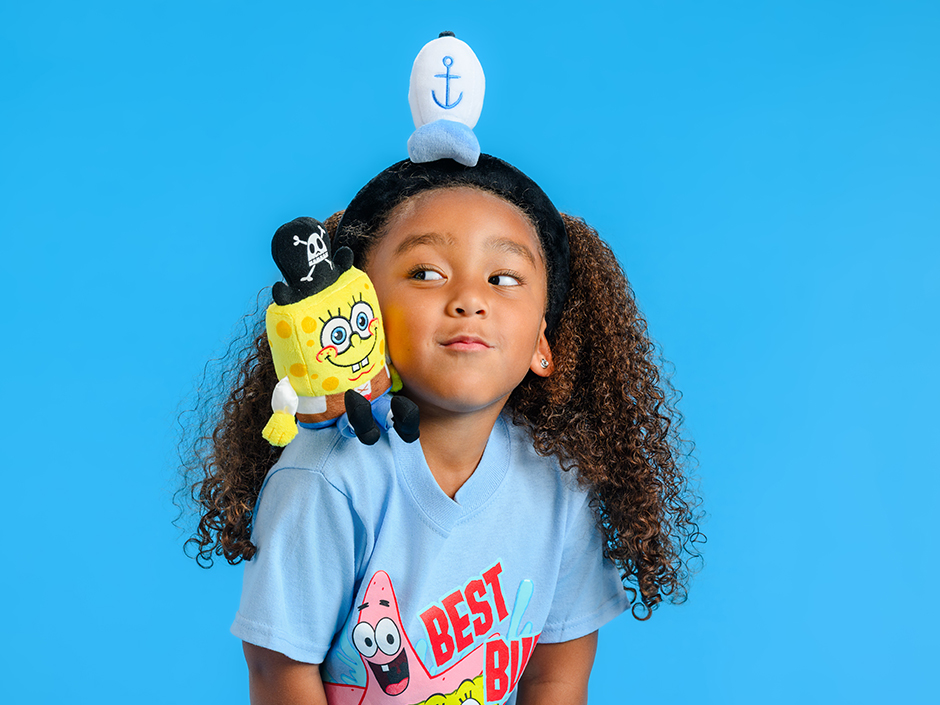 A little girl is wearing a Spongebob shirt and a plush on her shoulder