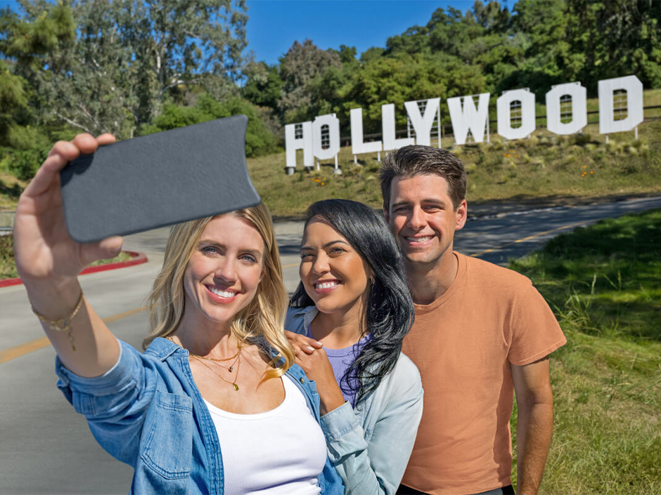 A group takes a selfie in front of the Hollywood sign replica at Universal Studios Hollywood.
