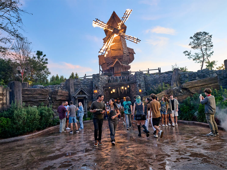 Guests walk out of The Burning Blade Tavern in Dark Universe as the windmill blades are set ablaze