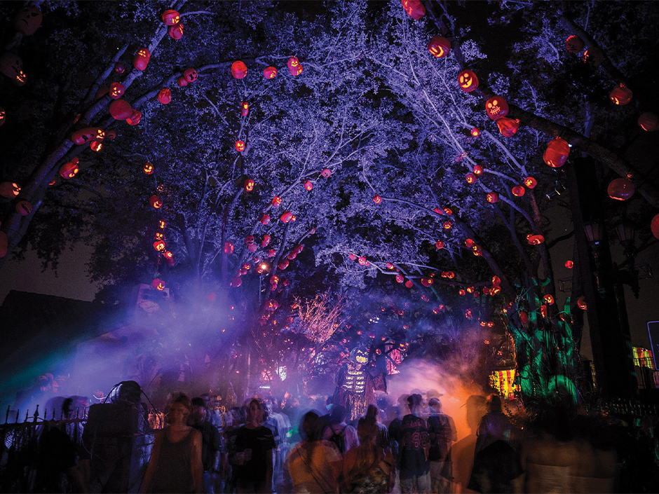 Guests walk through the fog of a scare zone filled with pumpkins in the Central Park area of Universal Studios Florida