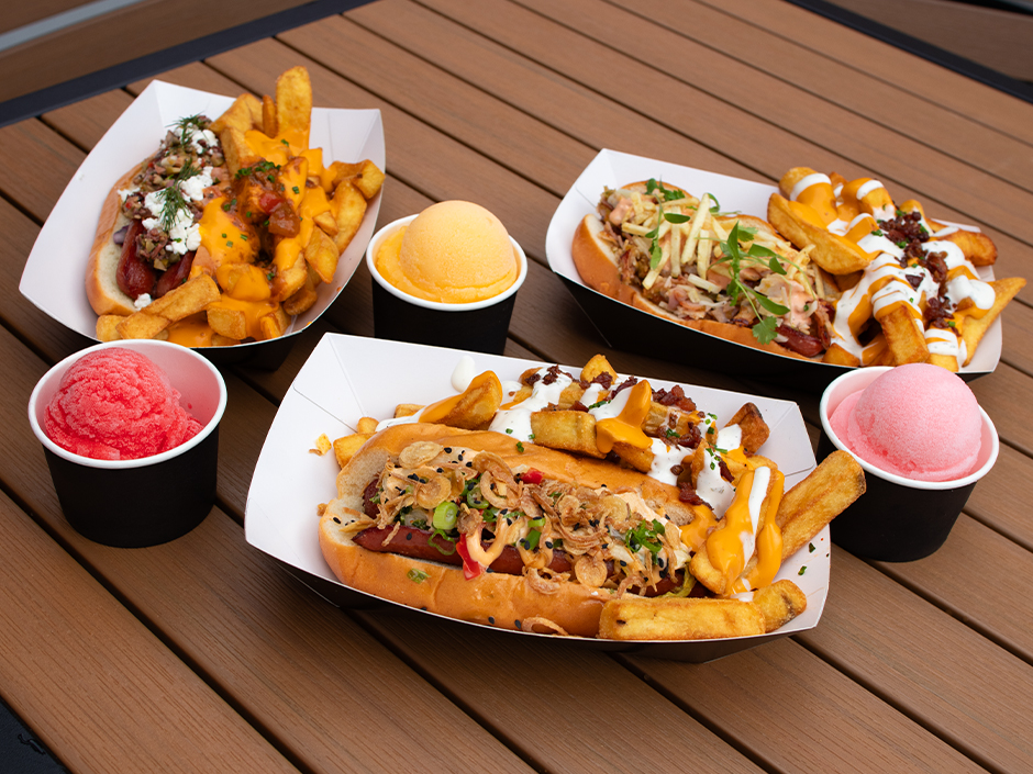 Three hot dogs available from Fat One's at Universal CityWalk alongside three flavors of Italian ice: cherry, mango, and cotton candy