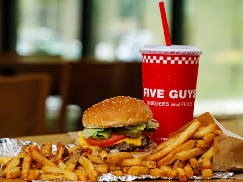Five Guys burgers and fries sitting on a table inside the restaurant at Universal CityWalk