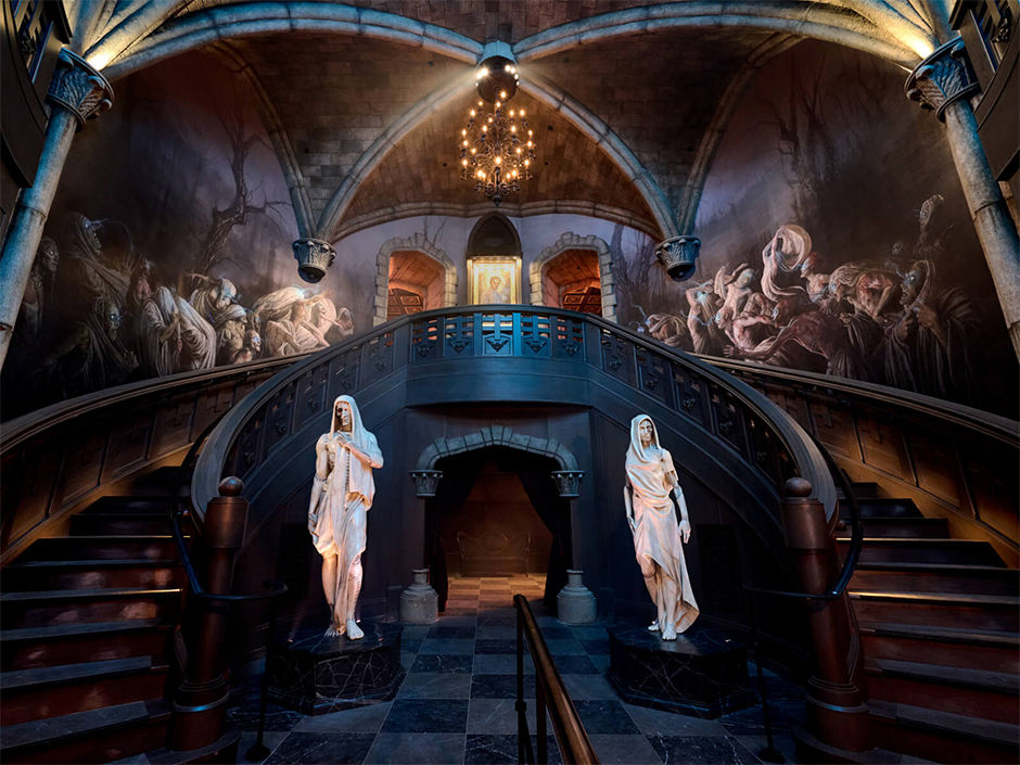 The interior of Frankenstein Manor featuring a portrait of Henry Frankenstein, several statues, and a wall fresco