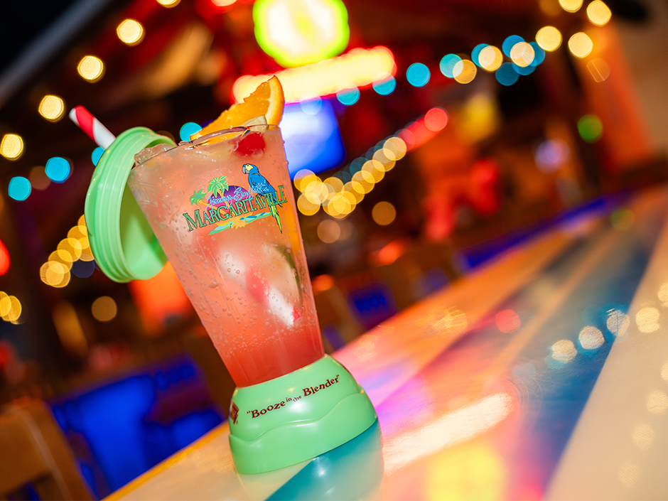 A margarita in a themed glass sits on a bar counter in Jimmy Buffett's Margaritaville