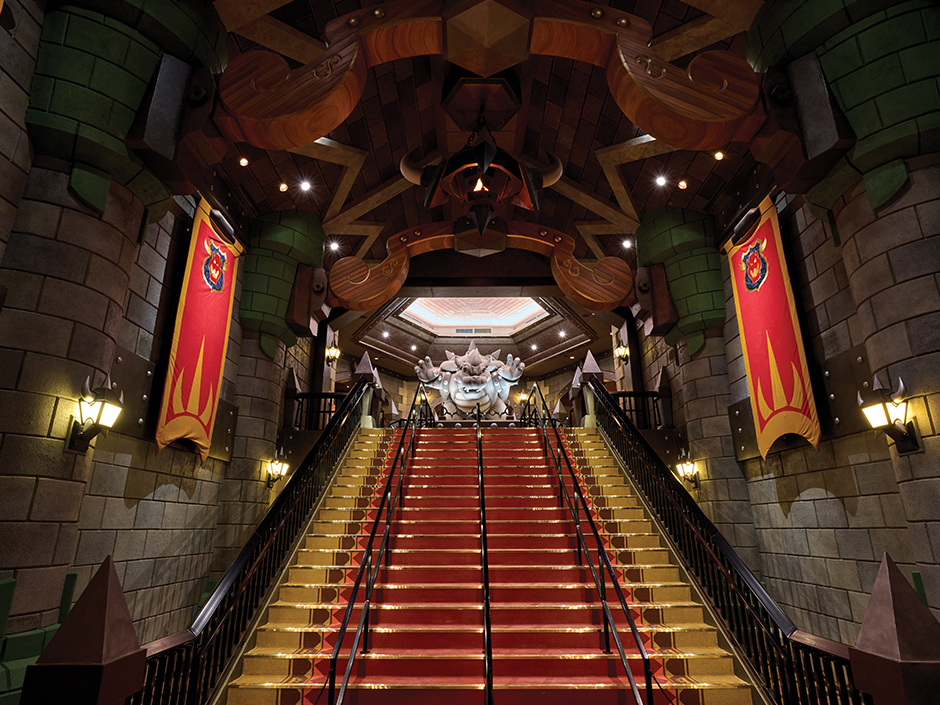 Stairs leading up to a statue of Bowser inside the queue for Mario Kart: Bowser's Challenge