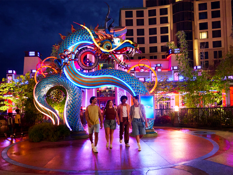 A group of 4 friends walks under the blue dragon.