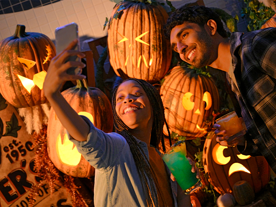 Girl and boy taking a selfie with pumpkin patch