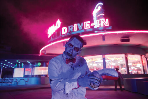 A zombie carhop poses for a photo outside of Mel's Drive-In during HHN