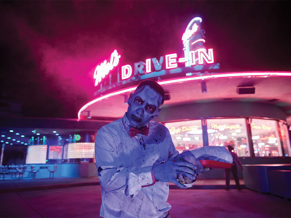 A zombie carhop poses for a photo outside of Mel's Drive-In during HHN