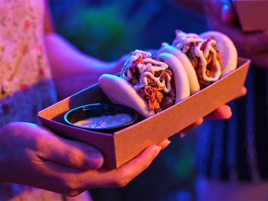 A guest holds a container of kimchi bao from Star Sui Bao in Epic Universe